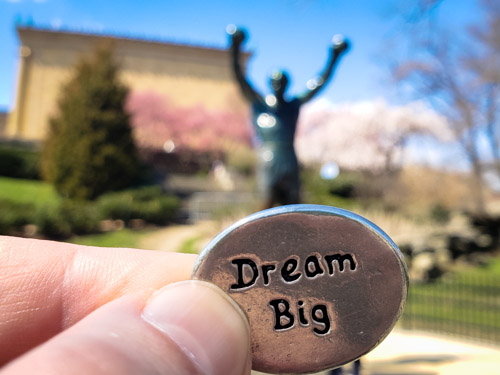 Dream Big coin in front of Rocky Balboa statue